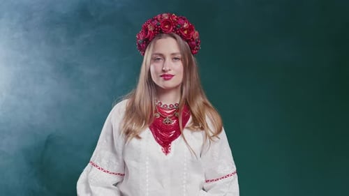 Beautiful Ukrainian Woman in Ethnic Costume on Blue Studio Background