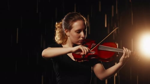 Woman Plays Violin With Dramatic Lighting