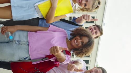 Smiling Students Give Thumbs Up on School Grounds