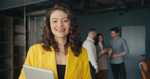 Smiling Woman Holding Laptop in Office Environment