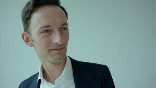 Close-up of face of suited caucasian man turning head and smiling