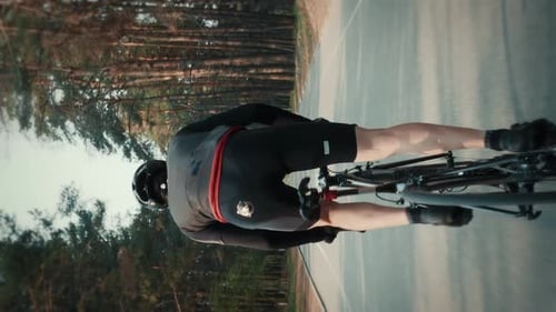 Man riding bike, hard training and pushing pedals out of saddle. Vertical video