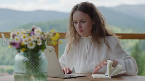 Focused Self Employed Woman Working on Netbook on Veranda in Mountains