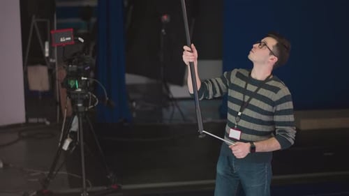 Man Holding Boom Microphone Adjusting in Studio Broadcast Video Production
