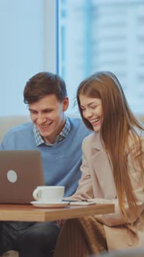 Vertical Screen Happy Couple Sitting in Cafe and Using Laptop