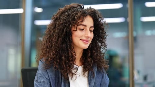 Confident Young Businesswoman Smiling at Camera in Modern Office