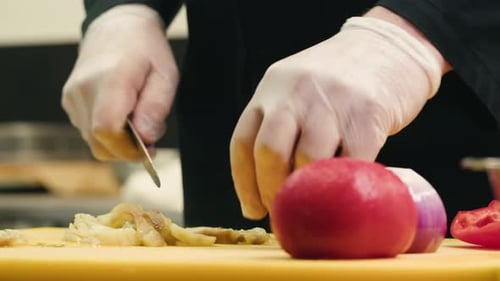 Der Koch schneidet eine Aubergine mit einem Messer und schneidet gebratenes Gemüse, gegrillter Salat, Gemüsemischung für