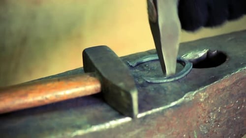 Blacksmith forging horseshoe on anvil traditional metalwork in workshop