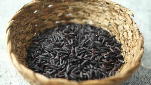 Black Rice Grains Being Poured into Bowl