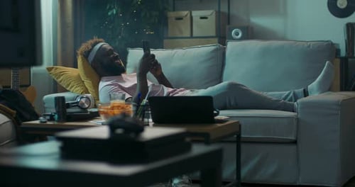 Young Adult Relaxing at Home with Smartphone