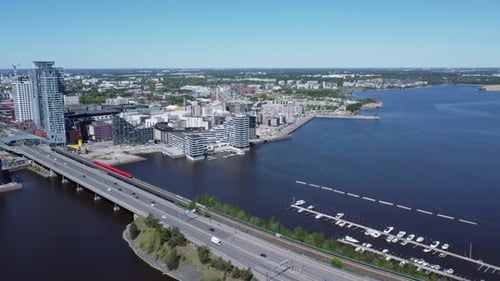 Automobile and train commuters cross Kulosaari Bridge in Helsinki, FIN