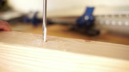 Close-up of drilling a hole in wood with a half inch drill bit