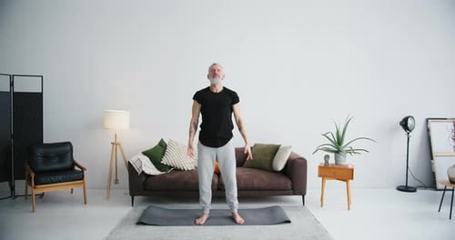 Mature Man Practicing Yoga in Living Room