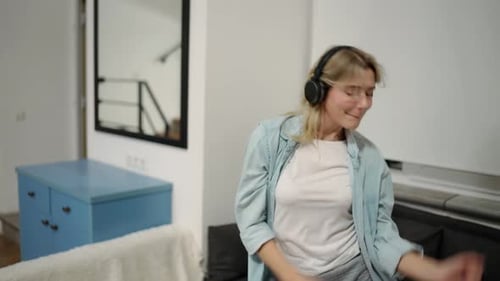 Energetic Woman Dancing with Headphones at Home