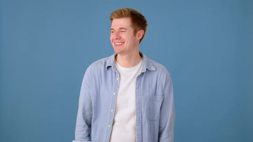 Smiling Man Gives Okay Gesture on Blue Background