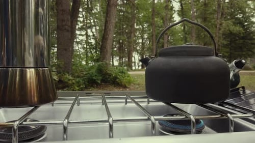 Camping Kettle With Steam On A Stove With Low Fire Outdoor. close up