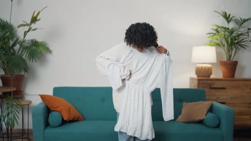 Garota afro-americana experimenta um vestido em casa Linda mulher está se preparando para um evento importante