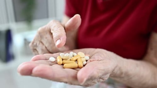 Senior Counting Pills in Hand Indoors During Daytime