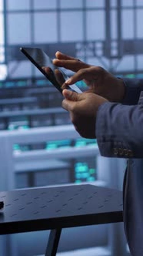 Vertical Video IT Expert in Data Center Holding Tablet Replacing Storage Mainframes Components