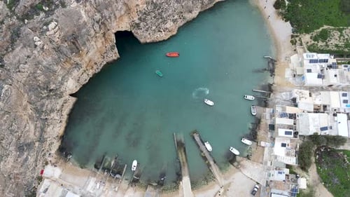 Dwejra seawater lagoon linked to the Mediterranean sea in Gozo island, Malta. Aerial top drone shot