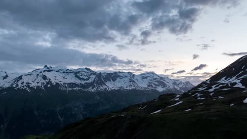 Vue hyperlapse du paysage serein du Mont Cenis montrant des sommets enneigés, sous un ciel nuageux, parfaite