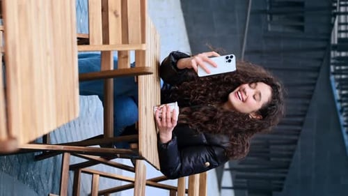 Smiling Woman Poses with Phone Outside