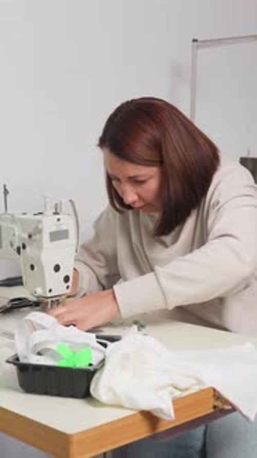 Une couturière s'est concentrée sur la création méticuleuse de prototypes de vêtements à la lumière du jour pour une femme caucasienne