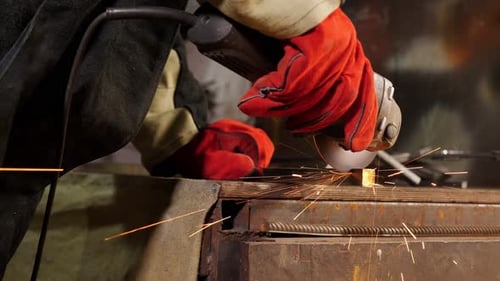 Man Grinding Metal With Sparks in Factory