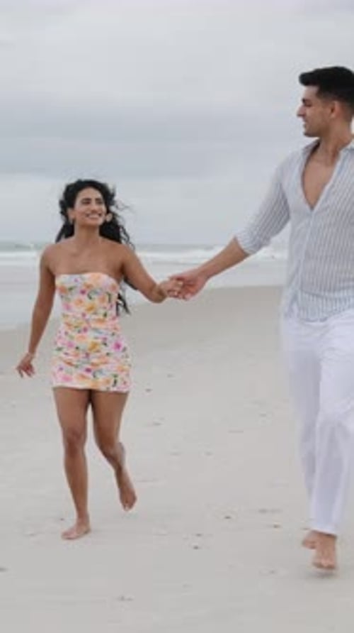 Happy Couple Holding Hands Running on the Beach