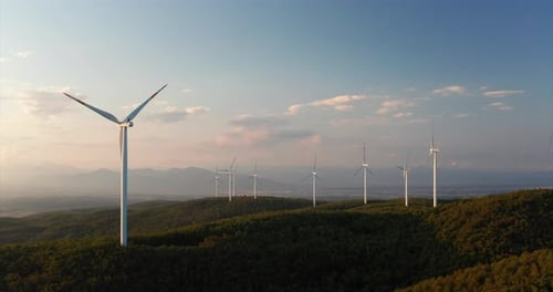 Aerial shot of wind mills rotating by the force of the wind and generating renewable energy in a g