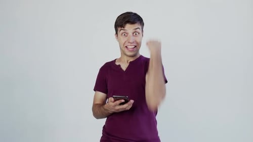 Excited male man winner looking at mobile phone using app celebrating success, hand gesture yes!