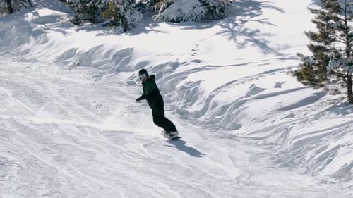 Snowboarder fährt einen verschneiten Berghang hinunter — Winterabenteuerszene