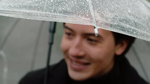 Young Adult Under Umbrella in Rain