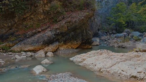Serene forest creek with rocky waterfall and clear turquoise water nature scene