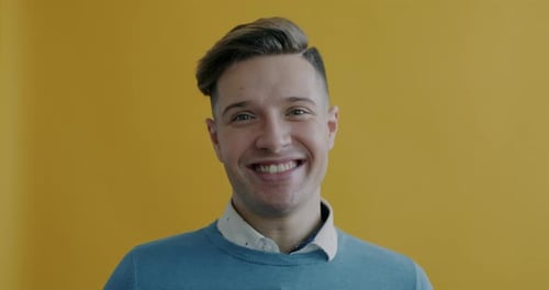 Smiling Young Adult Close-Up on Yellow Background
