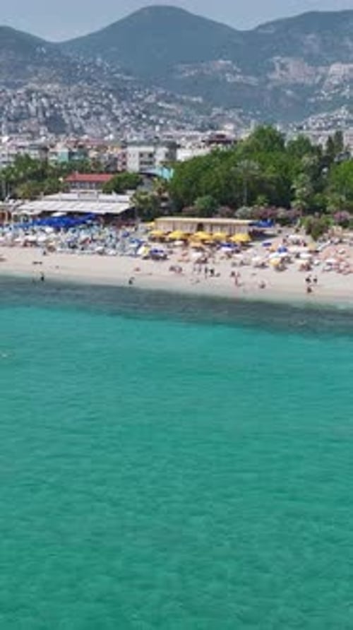 Vertical Video Busy Beach Club on the Mediterranean Coast With Relaxing Vacationers and Sparkling