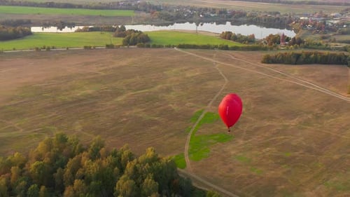 Heart Shaped Balloon Drifts Over Countryside at Sunrise
