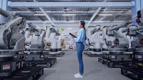 Woman With Tablet Inspecting Industrial Robot Arm Factory