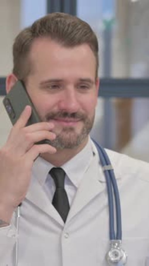 Adult Male Doctor Talking on Phone in Hospital