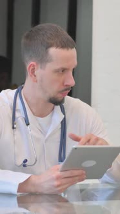 Doctor Using Tablet for Telemedicine Consultation in Office