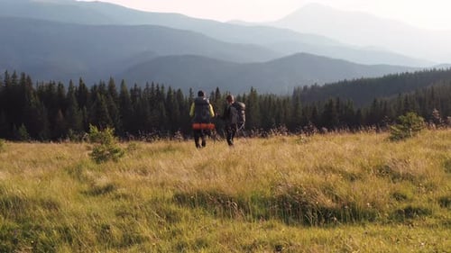 Couple of tourists walks up on hill. Majestic Carpathian Mountains. Beautiful landscape of untouched