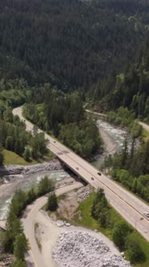 Vista aérea da majestosa rodovia e do rio sinuoso pelas exuberantes montanhas da Colúmbia Britânica