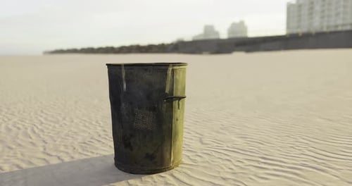 Unattended Trash Can on a Sandy Beach During Sunset Hours