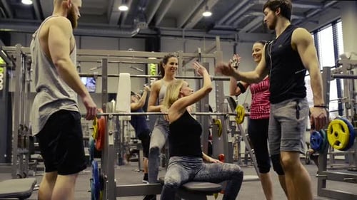 Young Friends in Gym Doing High Five After Finishing Bench Presses