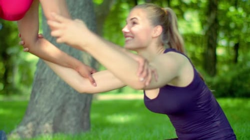 Caucasian woman stretching with friend in park for fitness and wellness
