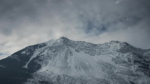 Epic winter mountains view with snow flying above the peaks