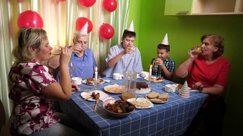 96. Celebrating grandmother's birthday, guests sit at the table, drink and treat themselves. Birthda