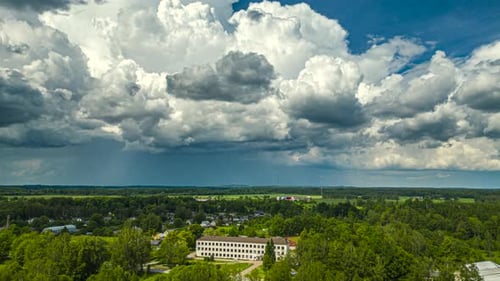 Billowing cloudscape and rainstorm over a village - aerial hyperlapse