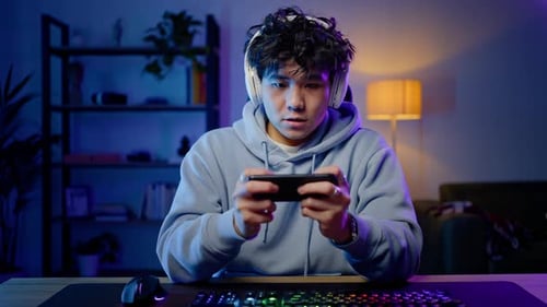 Young Adult Playing Mobile Game at Night