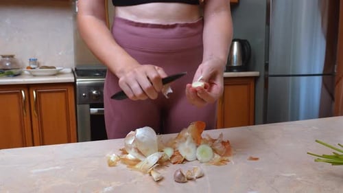 Ambiente de cocina informal con una mujer rompiendo dientes de ajo